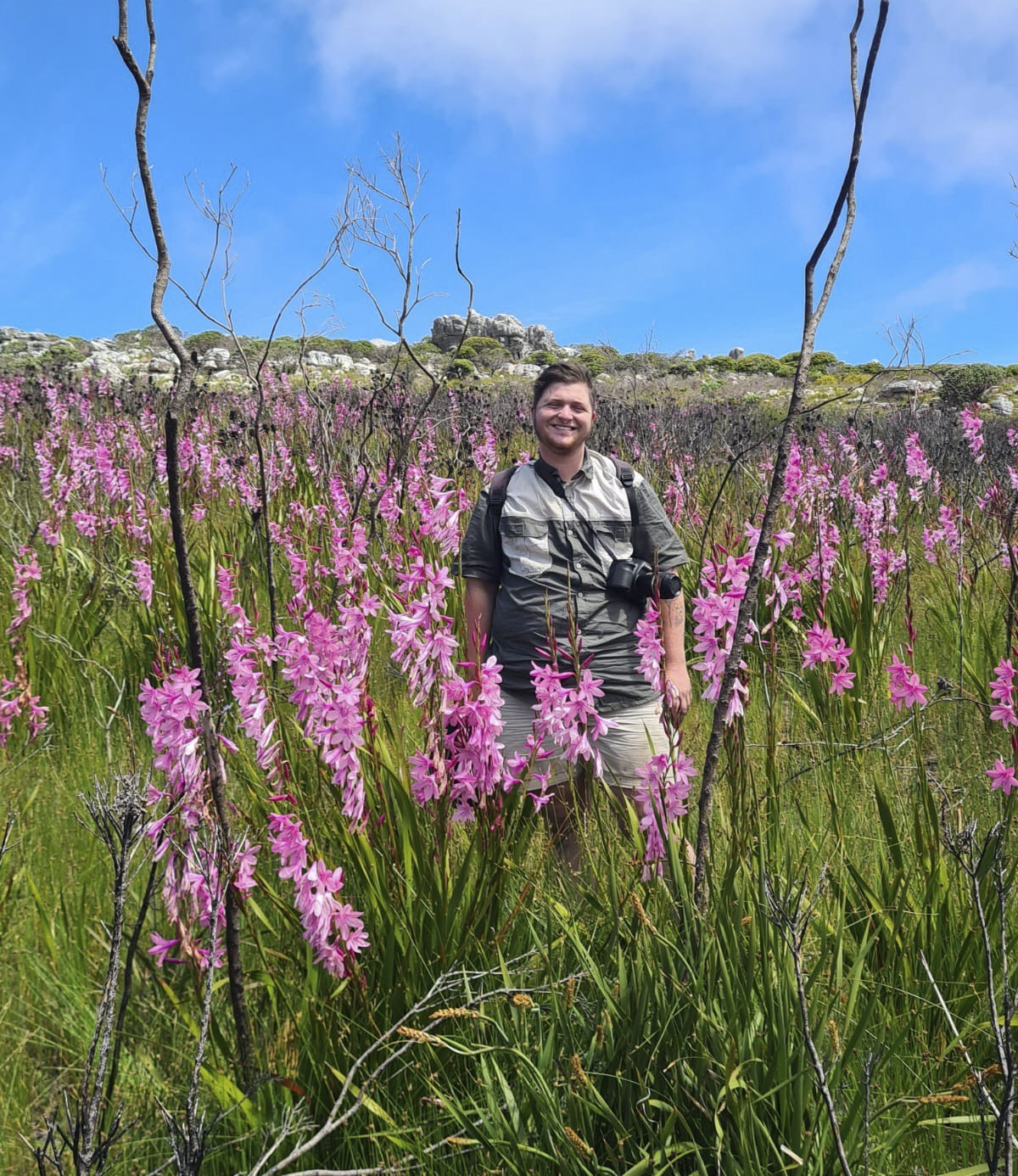 photograph of Sam McCarren in a field of flowering *Watsonia*